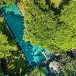 Asraya villa aerial view of villa rental with long rectangular pool and dense tropical garden foliage sanur 870x500