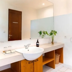 Asraya villa bright villa guest bathroom featuring a clean vessel sink wooden vanity marble countertop and a large mirror sanur 870x500