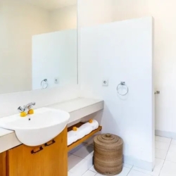 Asraya villa clean white guest bathroom with modern vessel sink large mirror and open wood shelving sanur 870x500