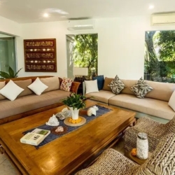 Asraya villa inviting villa living room with custom carved wooden sofas comfortable cushions and large windows offering garden views sanur 870x500