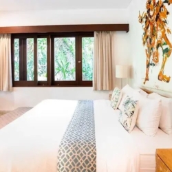 Asraya villa modern villa bedroom featuring a large bed dramatic abstract artwork wood framed windows and direct garden access sanur 870x500