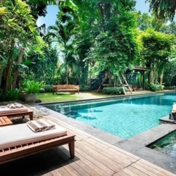 Asraya villa spacious outdoor swimming pool area with sun loungers and lush greenery sanur 870x500